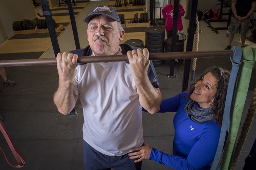 Recreation Therapist helping a Veteran do Pullups